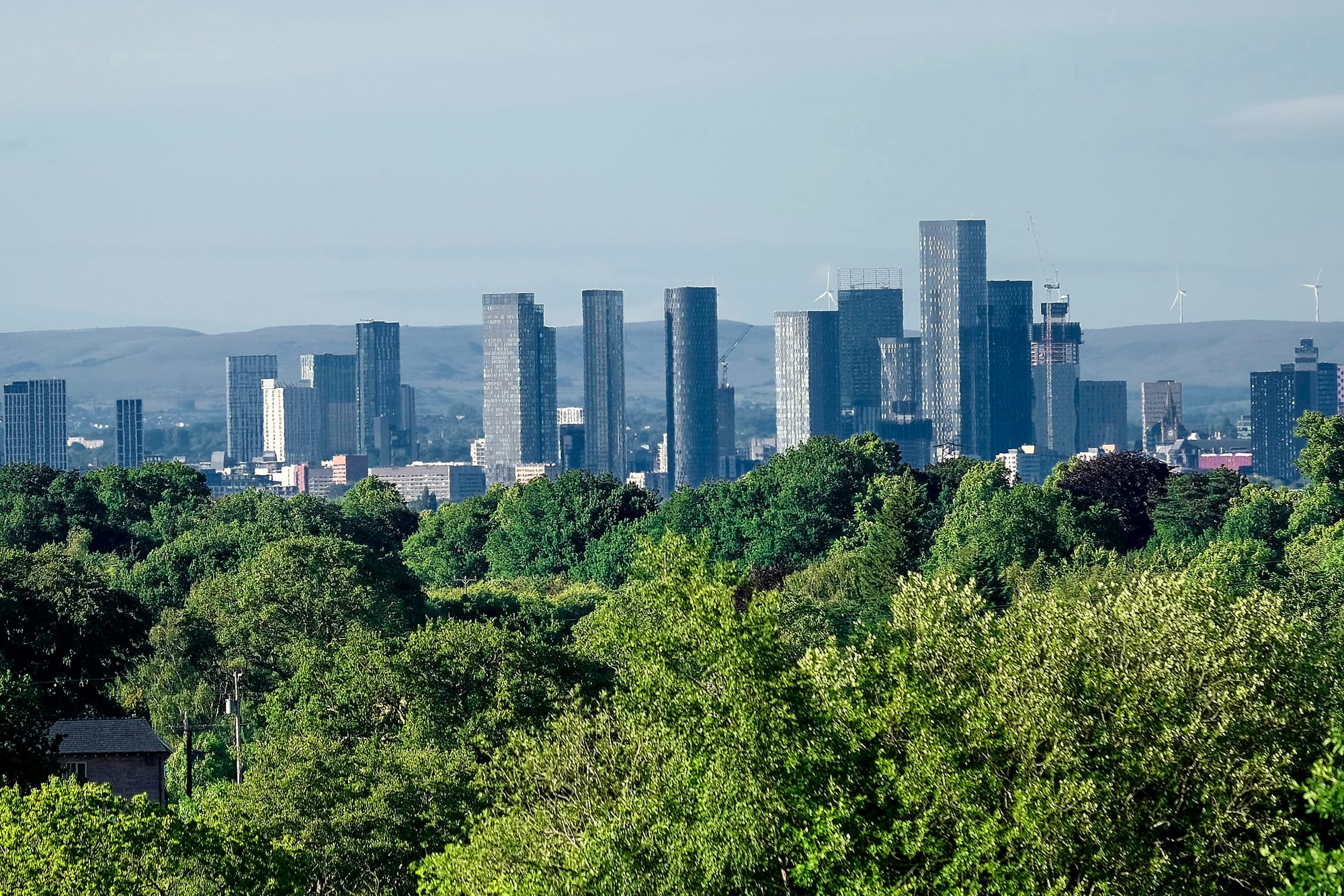 Manchester city centre towers rising above green parkland